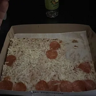 a person taking a slice of pizza
