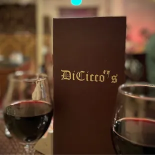 two glasses of wine and a menu