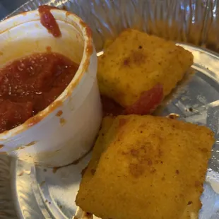 a bowl of tomato sauce and two crackers