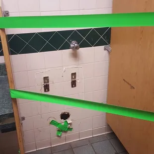 a bathroom with green tape taped around it