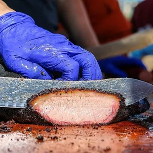 a person cutting a piece of meat