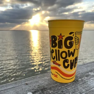 a yellow cup sitting on a dock