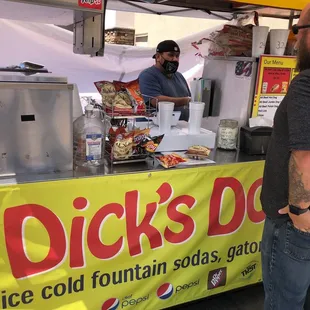 a man standing in front of a food stand