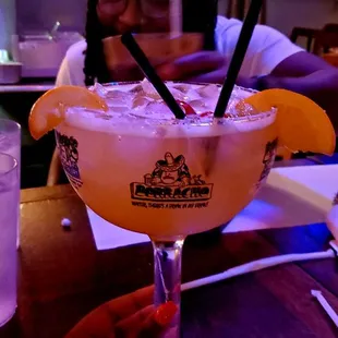 a woman sitting at a table with a margarita