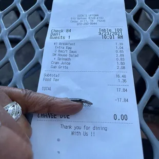 a receipt with a hand holding a pen