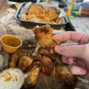 a hand holding a piece of fried chicken