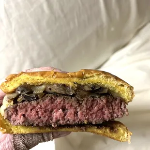 a hand holding a hamburger