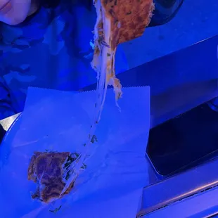 a woman holding a slice of pizza