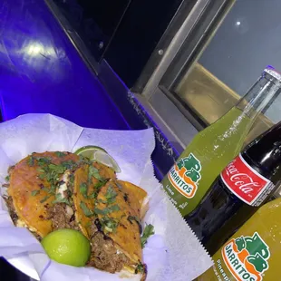 a plate of food and a bottle of soda