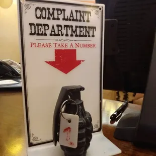 a sign that says complaint department please take a number