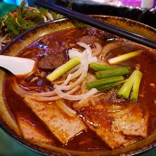 a bowl of soup and chopsticks