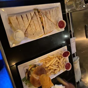 two plates of sandwiches and french fries