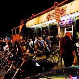 a line of motorcycles parked in front of a gas station