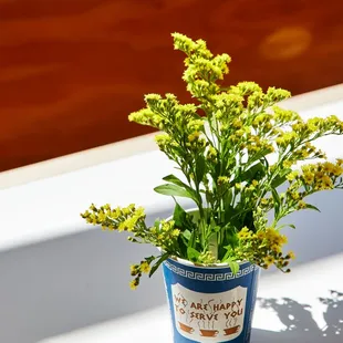 a flower pot with yellow flowers in it