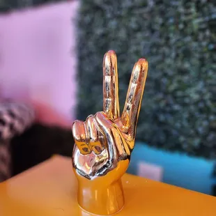 a gold hand with a peace sign