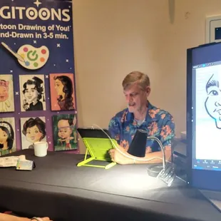 My son watching Tiki create a caricature of him.