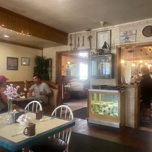 people sitting at a table with a fish tank