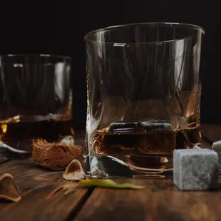 two glasses of whiskey with ice cubes