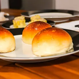 a plate of buns on a wooden table