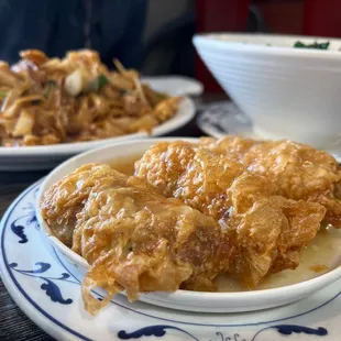 a plate of fried chicken and a bowl of noodles