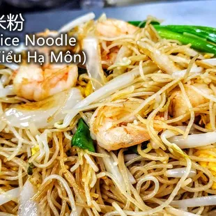 a plate of noodles with shrimp and vegetables