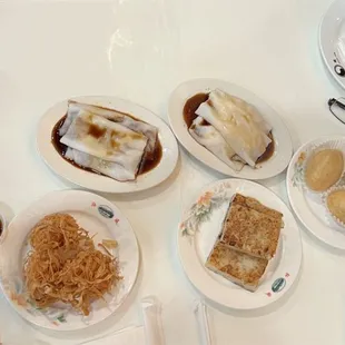 A variety of little plates of food. Shrimp Dumpling, Fried Pork Dumplings, Shrimp and Pork Cheung Fun, shrimp Balls, Turnip Cake