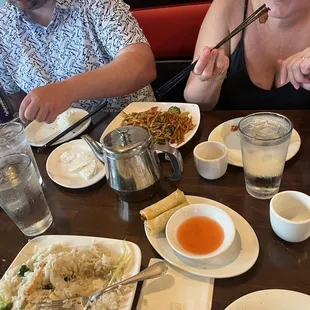 a woman eating a meal with chopsticks