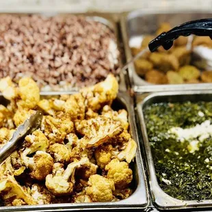 Fried cauliflower and black beans and rice on the back row right behind it.