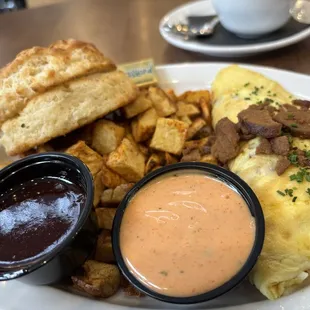 Ruben omelette Russian dressing on the side w biscuit.  Berry preserves.