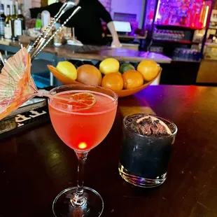 a glass of cocktail with an umbrella on the bar