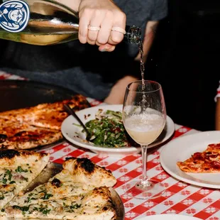 a person pouring wine into a glass