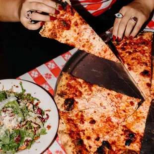 a woman cutting a slice of pizza