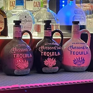 a row of liquor bottles on a bar counter