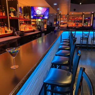 a bar with bar stools and a television