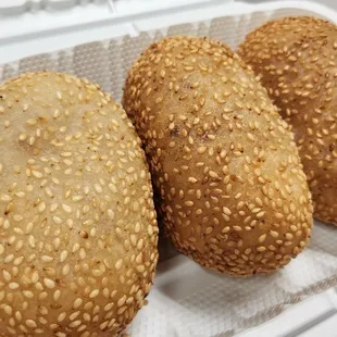 three sesame buns in a container