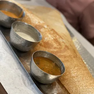 a pancake with dipping sauces