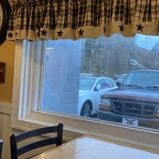 a view of a car parked in a parking lot through a window