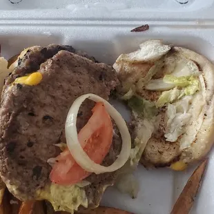 a hamburger and fries in a styrofoam container