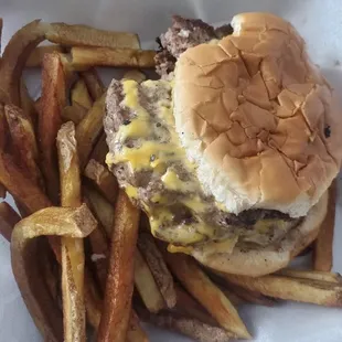 a cheeseburger and fries in a styrofoam container