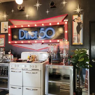 a diner&apos;s kitchen with a neon sign above the stove