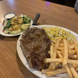 ows a steak and fries on a plate