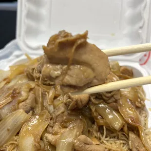 a close up of a plate of food with chopsticks