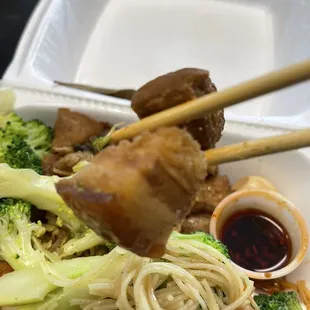 a plate of noodles with meat and broccoli