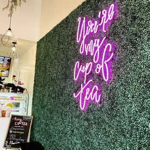 a green wall with a neon sign