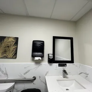 a bathroom with a toilet, sink and mirror