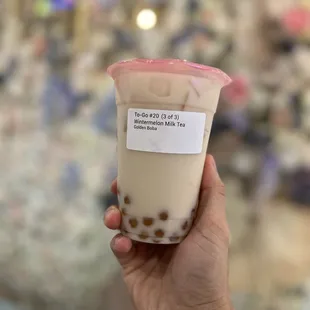 a hand holding a cup of bubble tea