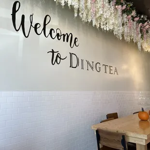 a table and chairs in front of a welcome to dining sign