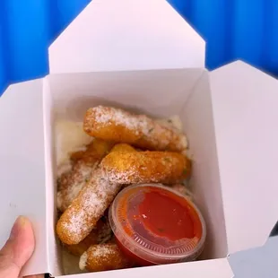 a person holding a box of doughnuts