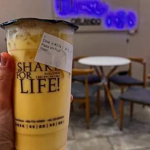 a hand holding a cup of iced tea