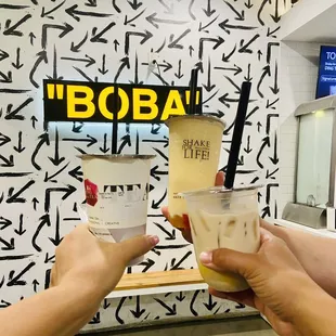 two people holding cups of tea